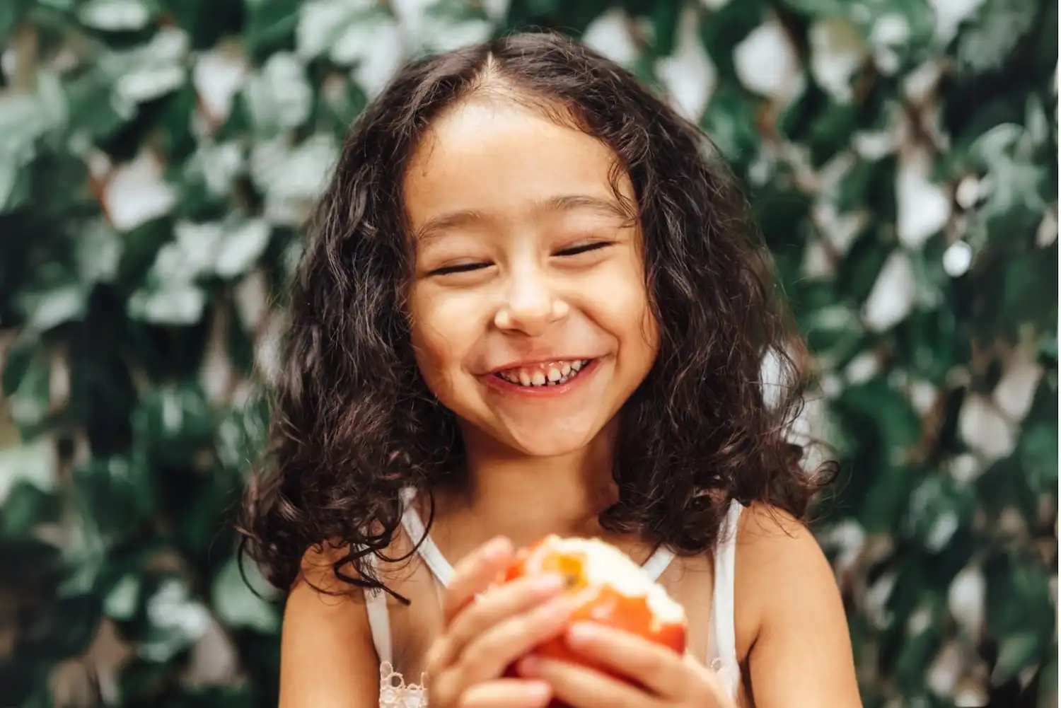 Happy girl eating an apple